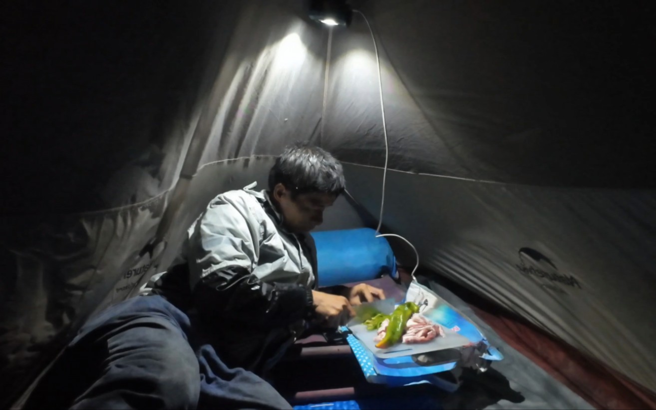 骑行新疆下雨了躲在狭小的帐篷里做饭吃，做饭吃饭睡觉都在帐篷里，这就是个可以移动的家