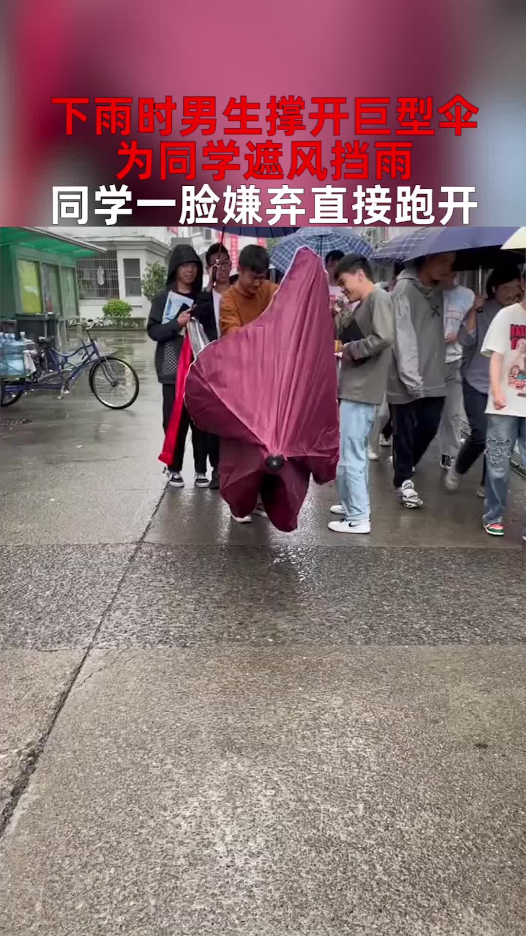下雨时男生撑开巨型伞，为同学遮风挡雨，同学一脸嫌弃直接跑开