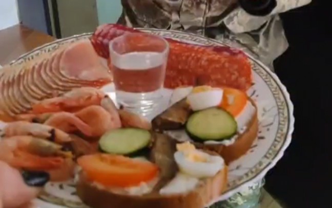 乌军回家欢迎仪式系列，三种香肠、大虾和夹了蔬菜鸡蛋的面包，配上一杯伏特加。