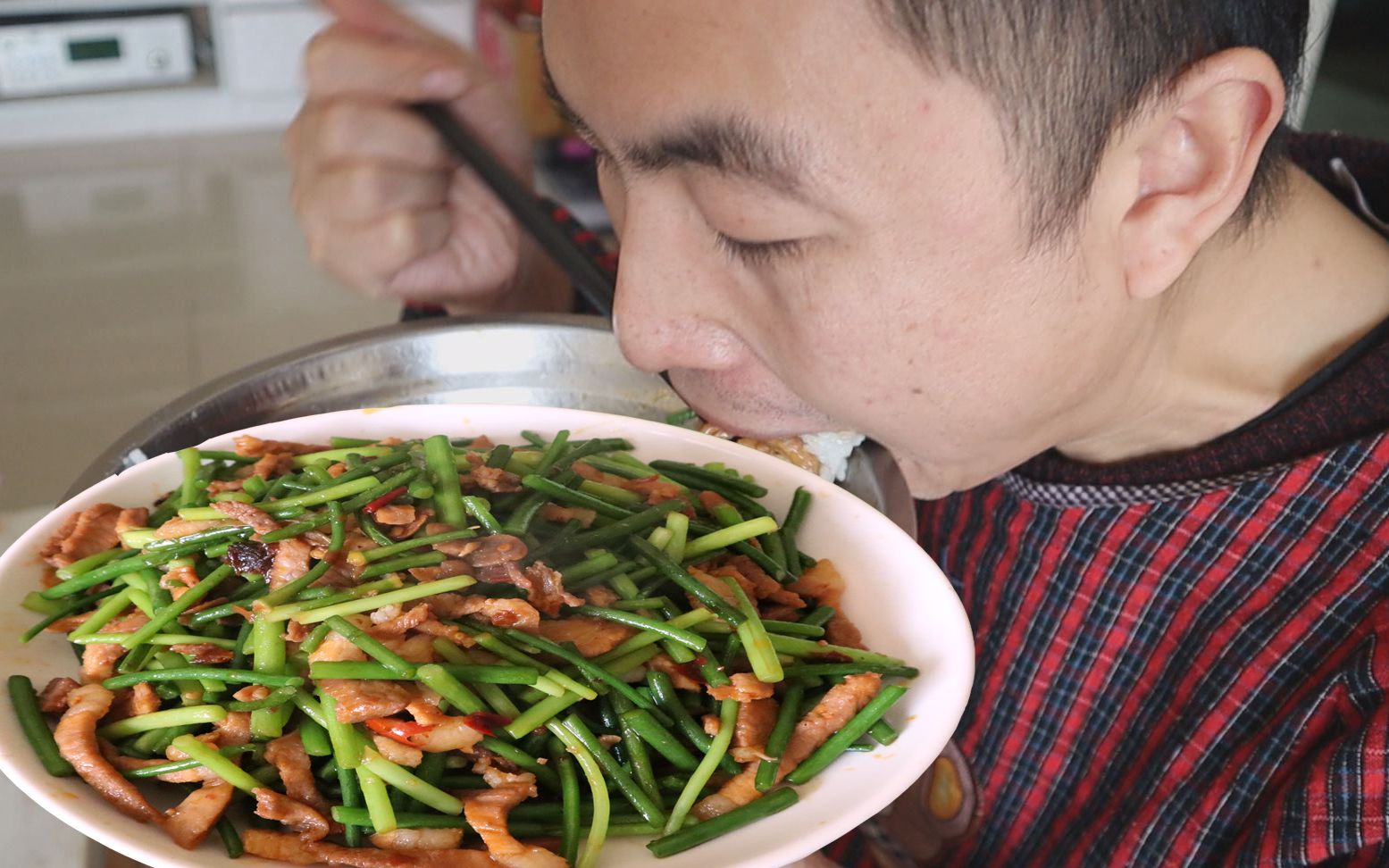 在地里打了新鲜蒜苔，用猪肉来炒，配上一盆米饭，下饭吃着真香