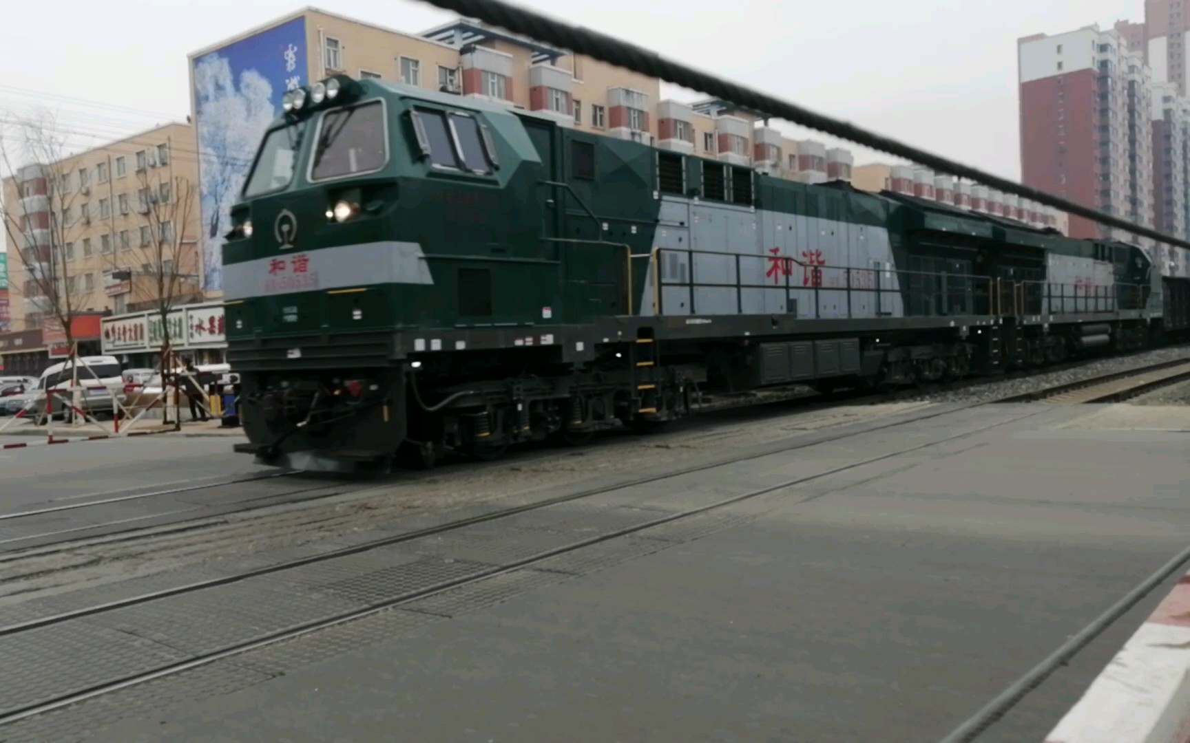hxn5型内燃机车牵引货车车厢及铁路槽罐车经过铁路道口