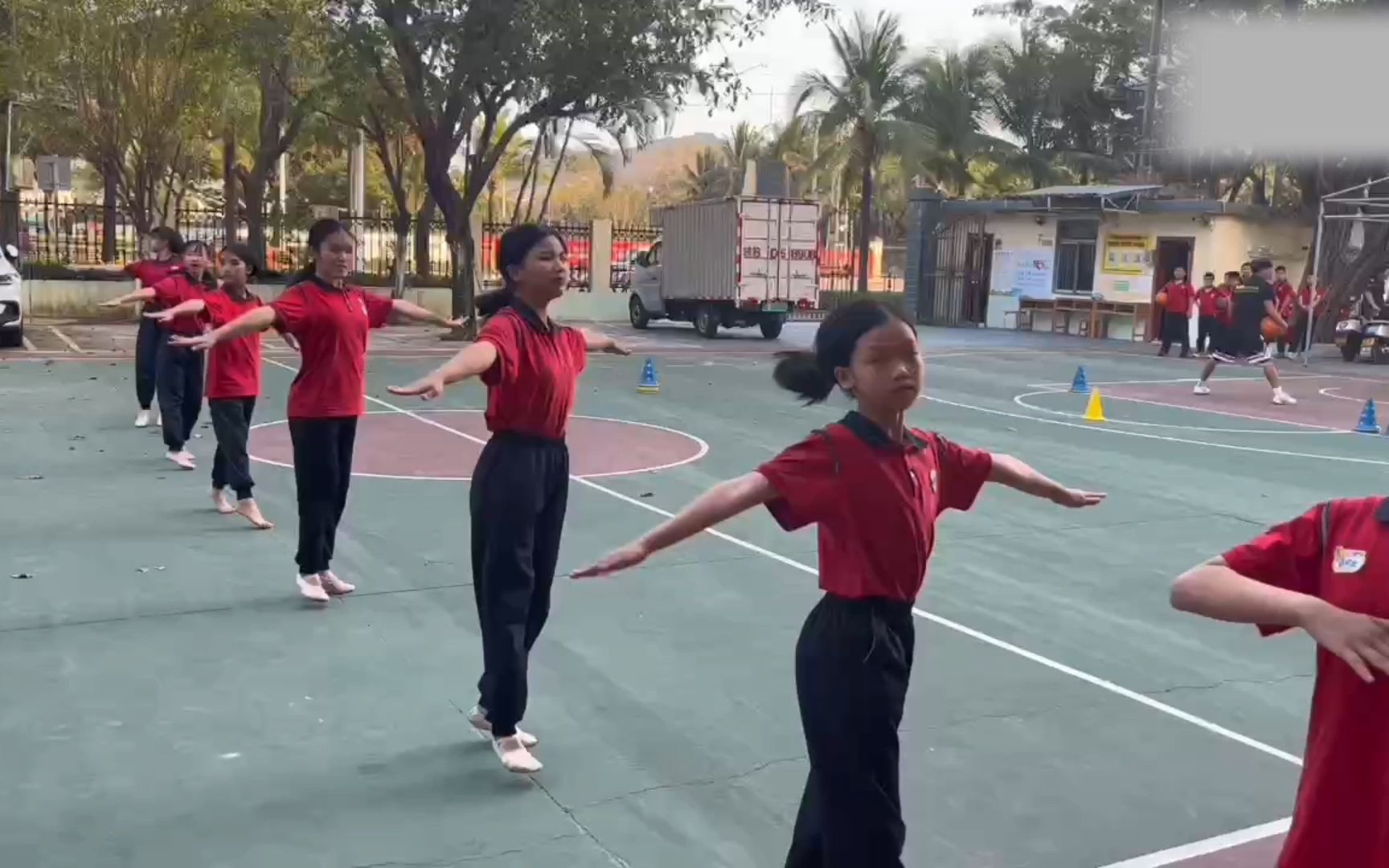 中学女生在篮球场光脚练习舞蹈