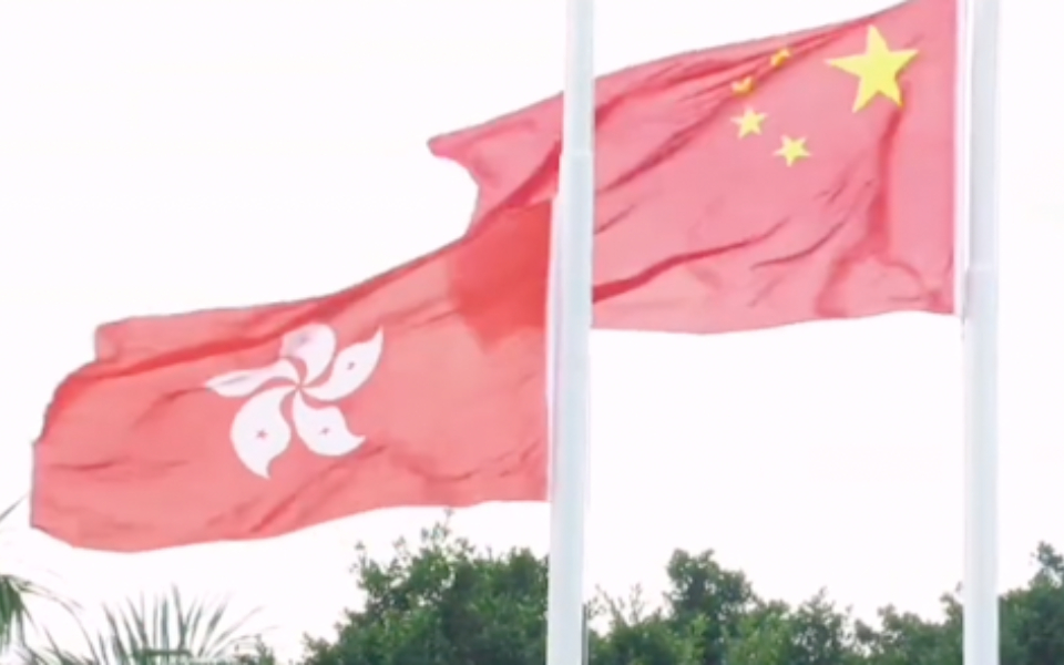香港举行国庆升旗仪式，直升机悬挂国旗、区旗从维多利亚港飞过。