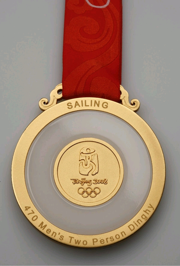 奖牌背面为金镶玉设计,中央为北京奥运会徽 奥运五环造型,周圈刻有
