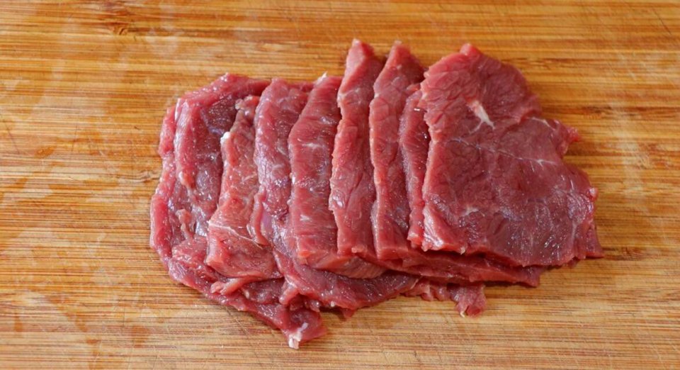 将切好的牛肉片改刀切成丝状,放入碗中.