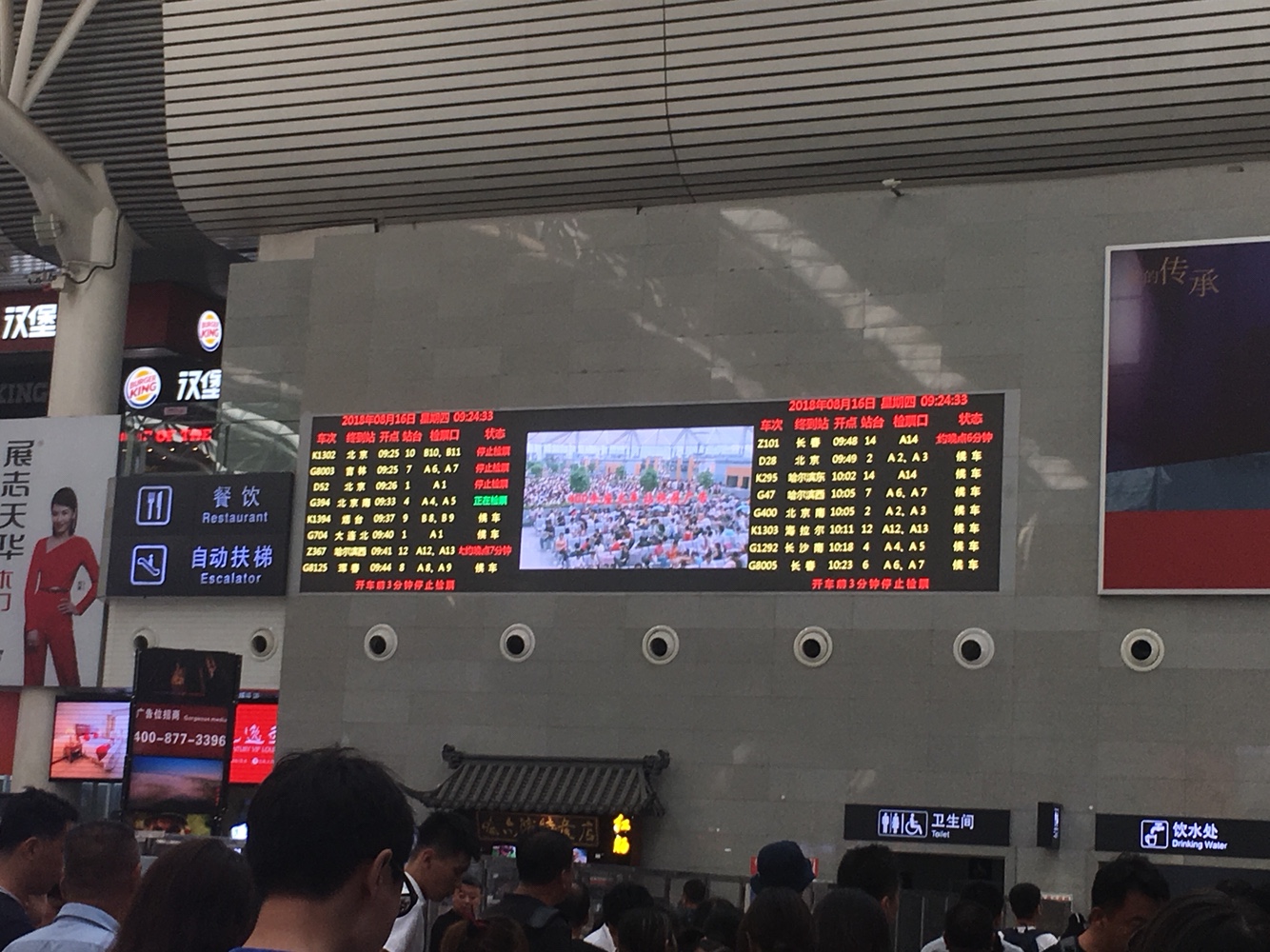 在候车大厅角落里的大屏幕显得有些抠抠缩缩