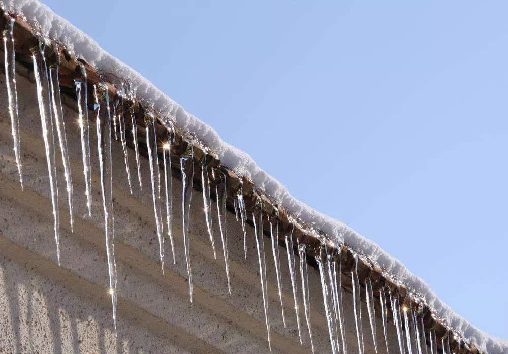 冬天楼顶上的落雪被阳光一晒便化成了水,流到阴面便冻成了冰凌,等到