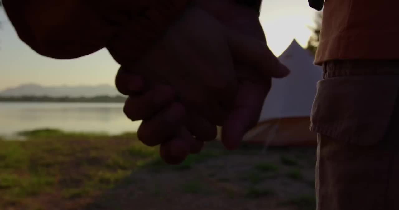 情侣两人牵手跑向湖边欣赏大自然