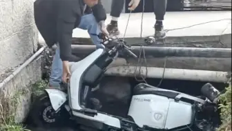乱停的电鸡被人一脚踢落臭水沟