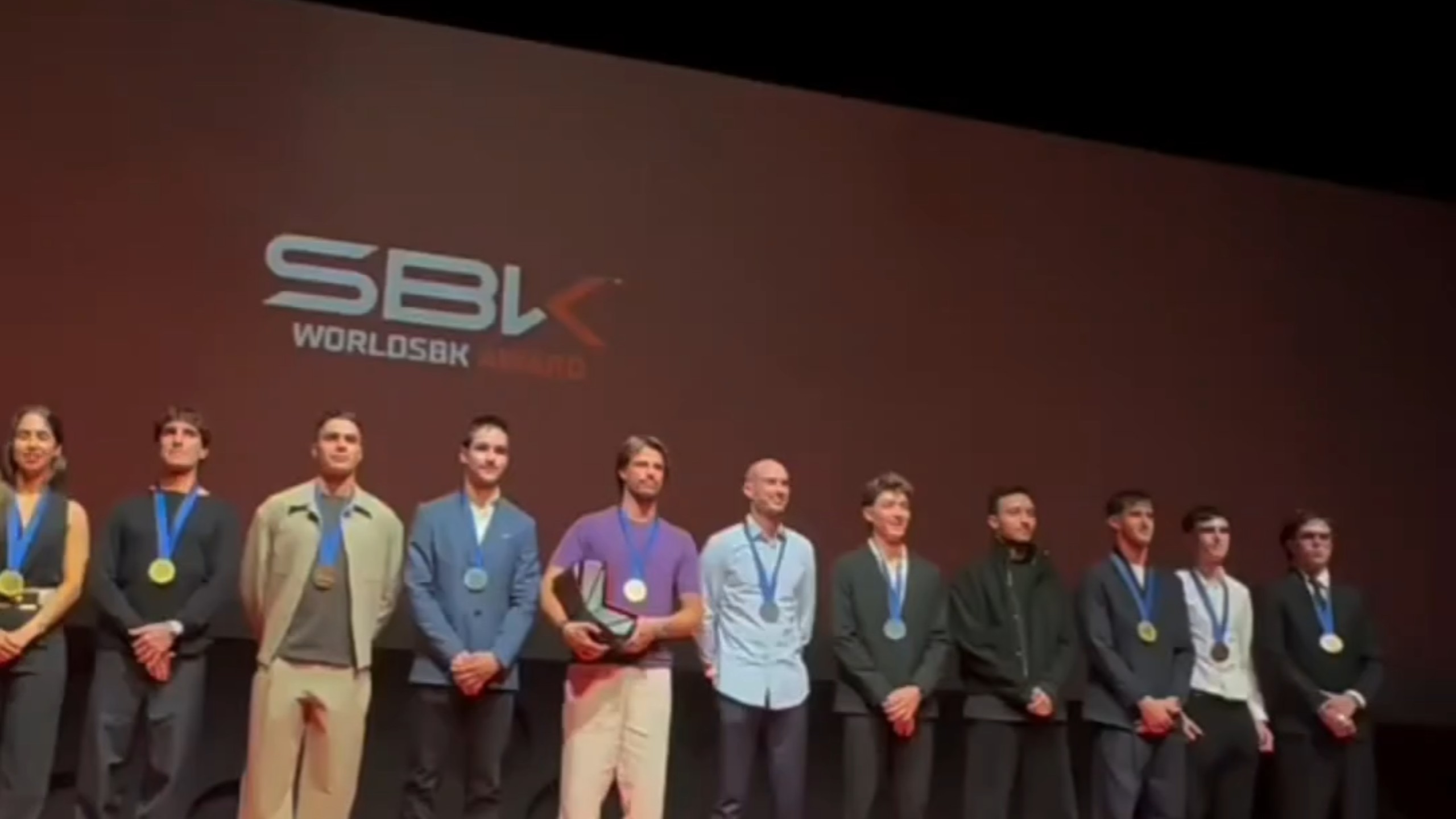 WSBK2026年度颁奖典礼，张雪机车的53号的德比斯满脸笑容，61号坎昂库一脸严肃，似乎很不开心