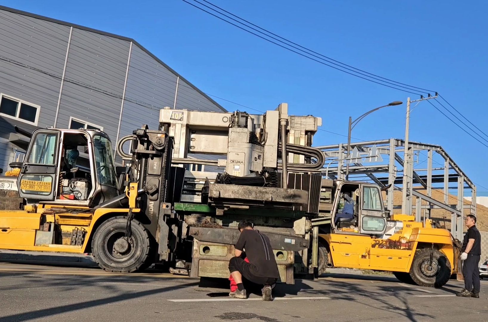 两台重型叉车搬运大型机床