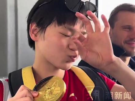 全红婵奥运夺冠后给外国友人展示金牌,"拿捏"的小表情太可爱:咱们拿