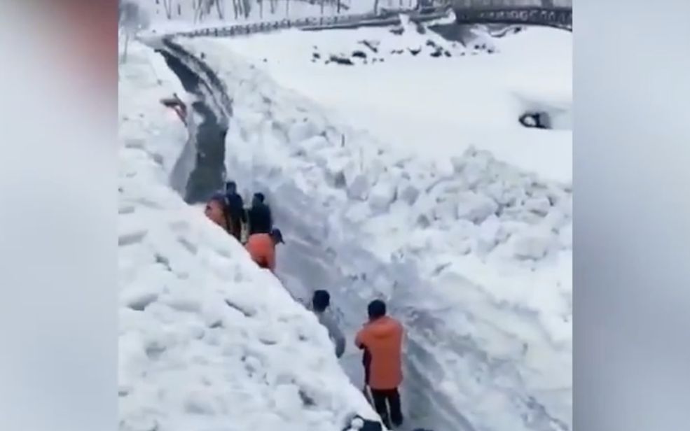 [图]长白山大雪连下10多天 积雪最厚深达2米 工人在雪墙下挖出道路