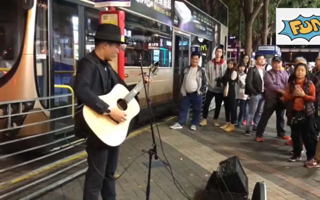 [图]香港电车站路口，弹唱《灰色轨迹》，匆忙的人也忍不住停下脚步，默默支持。