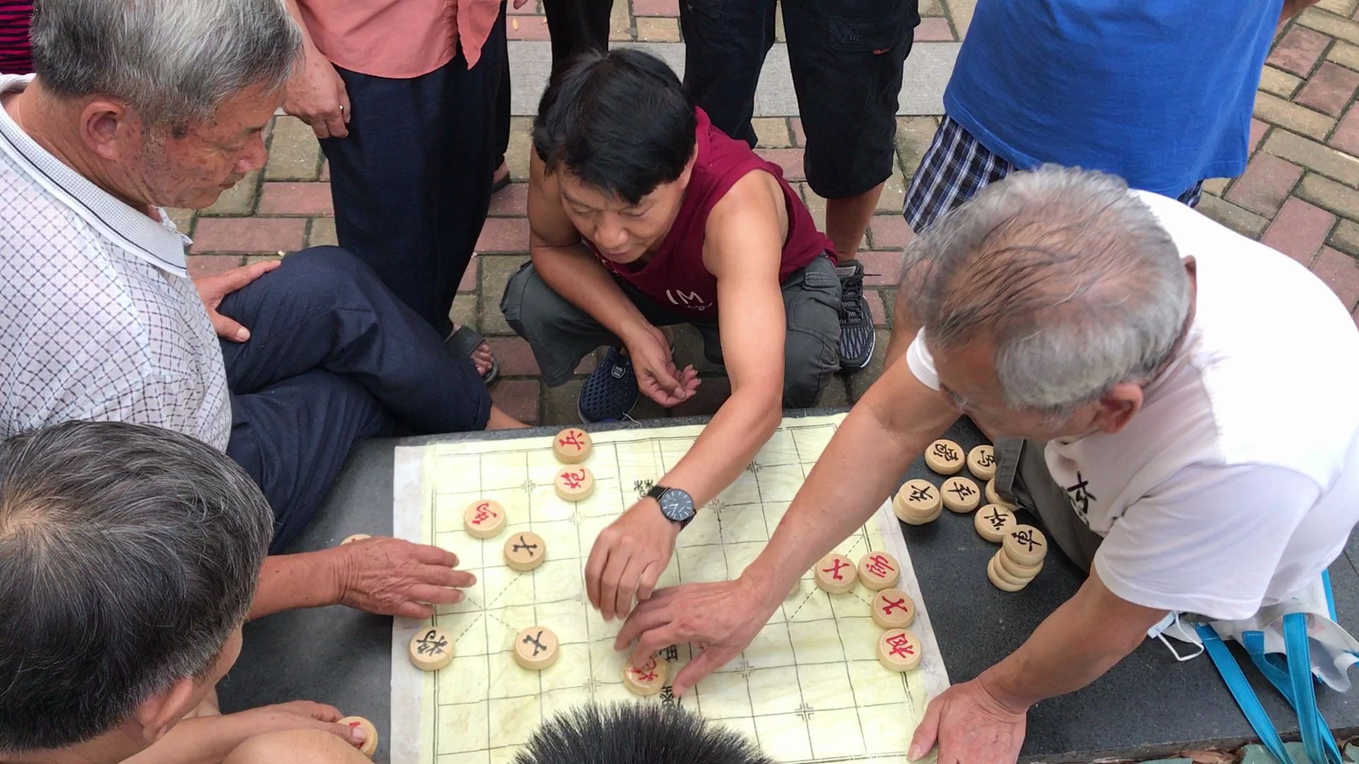 两个大爷下象棋,旁边围观者迫不及待自己动手了,大爷很无奈啊!