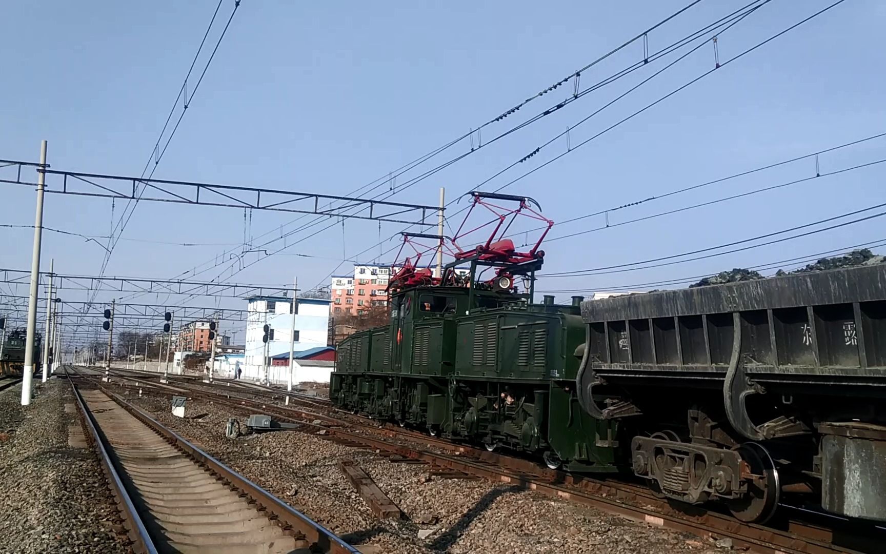 抚顺电铁自备37e-1 1537号电机车推着一组满载矿渣的kf列车驶出东舍场