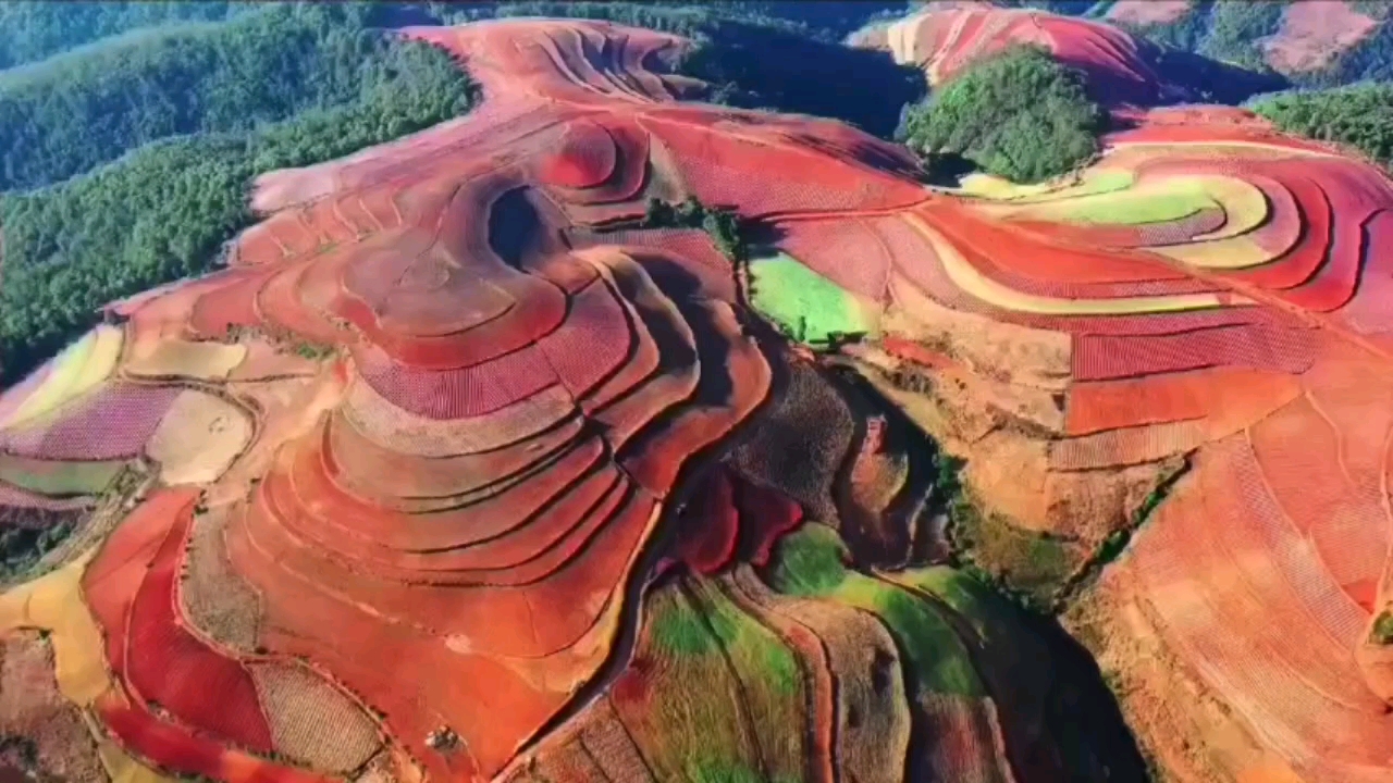 [图]位于云南昆明的东川红土地，红土高原上最具特色的红土地貌，层层叠叠的梯田里，火红的土壤被多种农作物分隔开来，织成了一幅色彩浓烈的画卷。