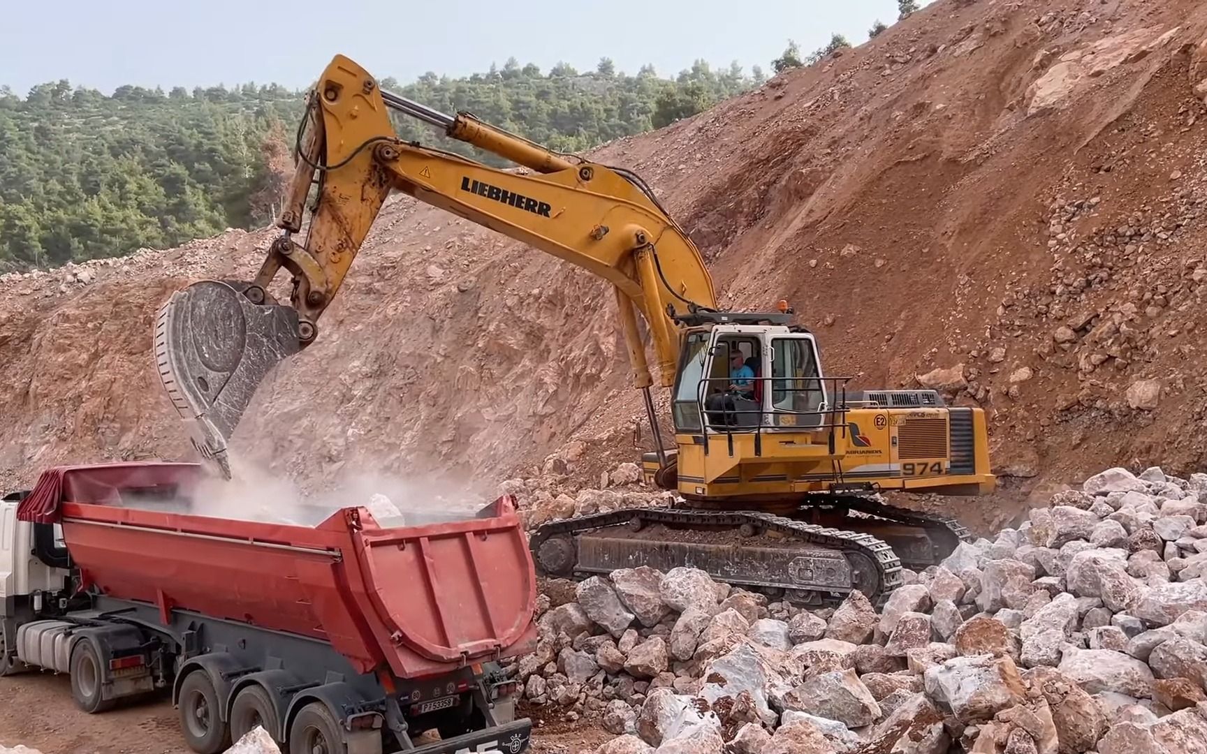 利勃海尔 974 挖掘机在采石场装载卡车 - sotiriadis/labrianidis 采