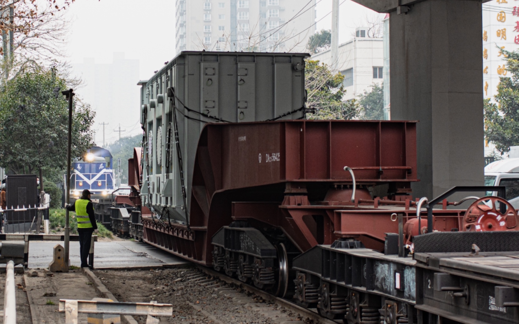 df7牵引装载变压器的da25型凹底平车驶过西电厂专用线西二环道口