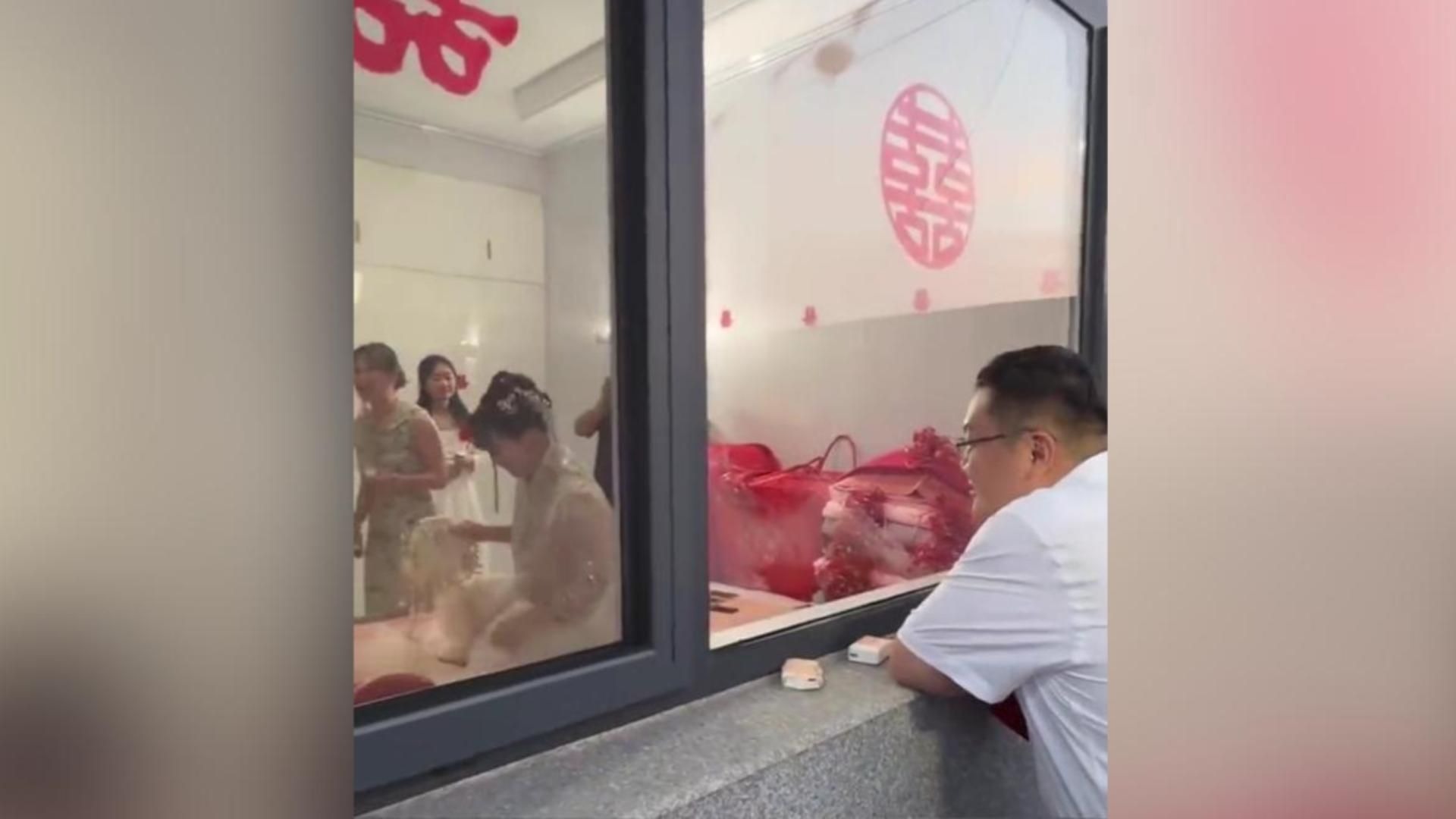 新郎不着急接媳妇呆呆看着新娘 娘家人堵门一小时 网友:男的这种动作其实已经生气了