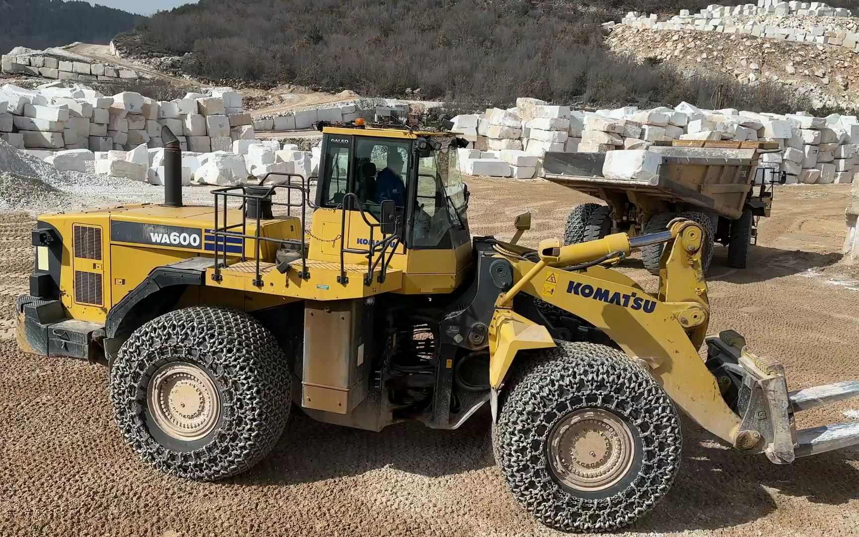 小松wa60轮式装载机从da的卡特彼勒翻斗车上卸下大理石块