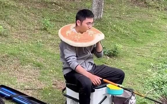 男子钓鱼在脖子上挂张饼,随时补充能量,网友:一定要记得转过来吃后面