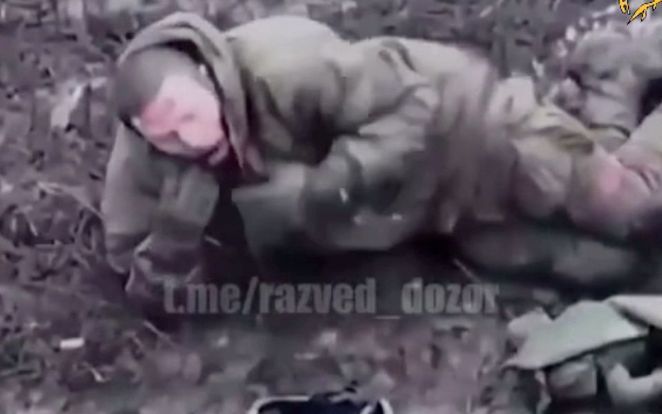 一名受伤的俄罗斯士兵被弹片炸伤后,脱下背心,点燃了一支香烟