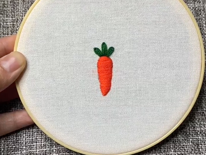 小小胡萝卜,绣在白色衣物上,增添一抹独特的风采