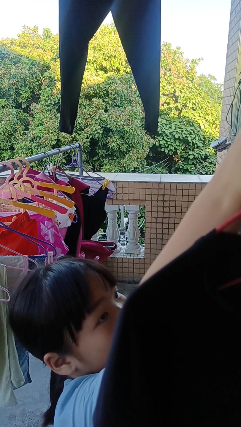 孩子在家晾衣服