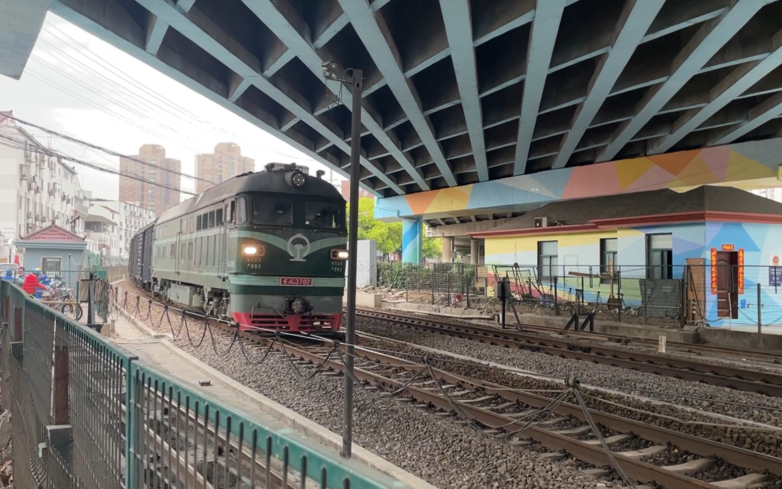 3702牵引棚车敞车平车编组的货物列车鸣电笛通过南何线场中路铁路道口