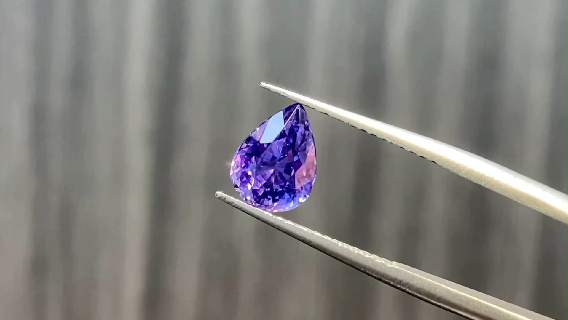 05ct的无烧紫蓝宝,晶体通透明亮,爆闪的火彩非常绚烂,艳丽的紫色略带