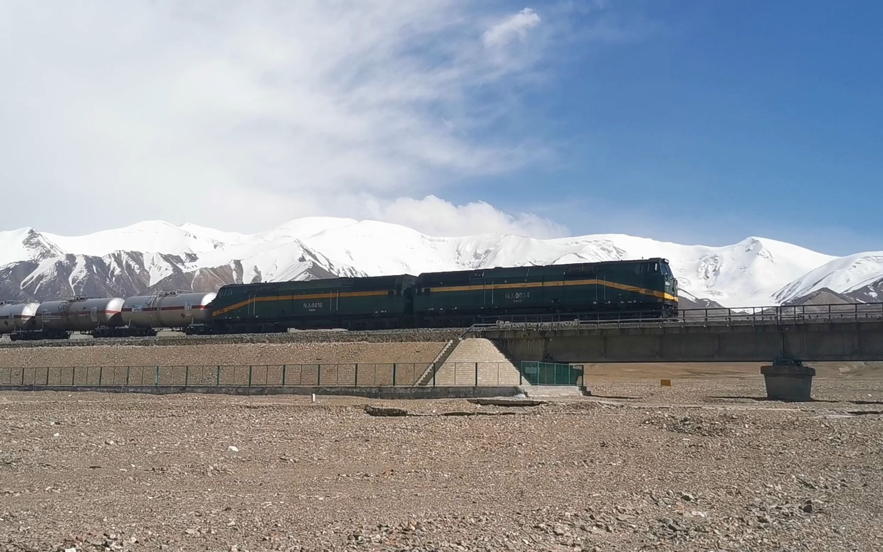 [图]青藏高原上的NJ2火车驶过雪山