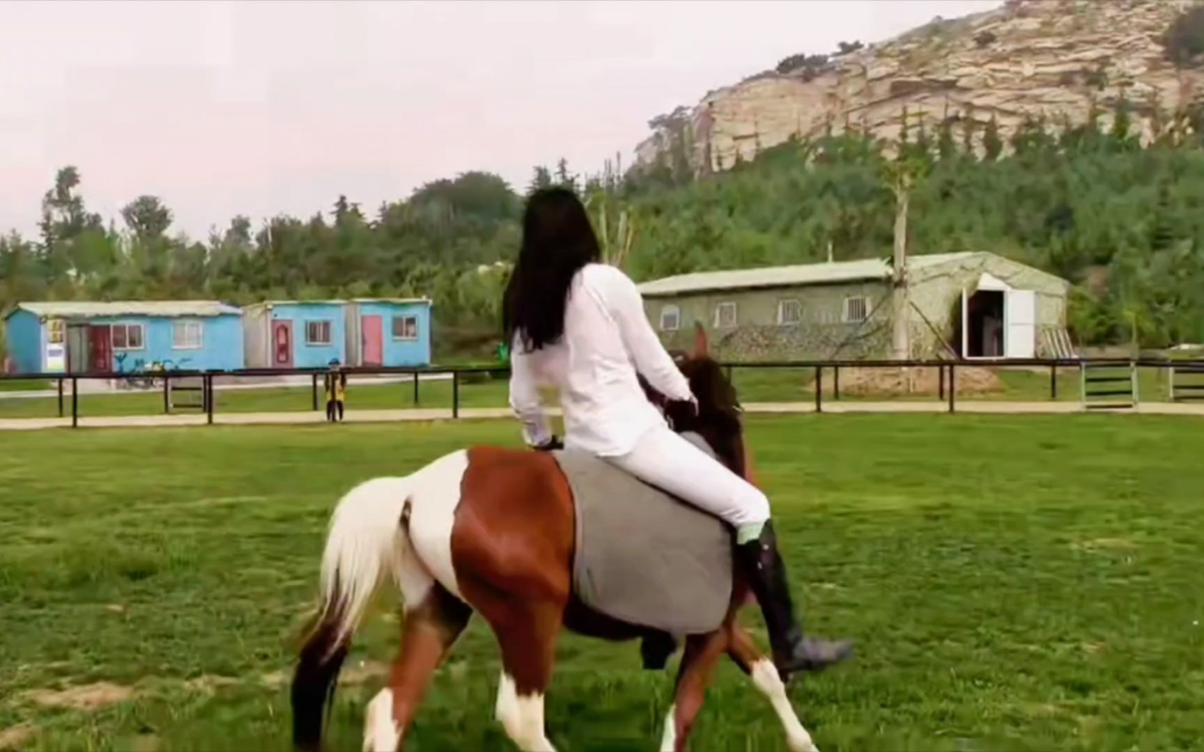 白衣女马场休闲骑小马