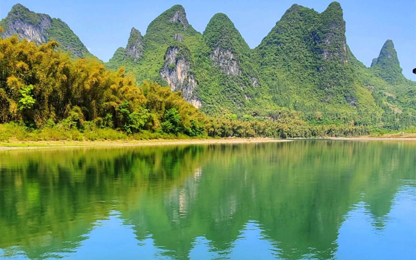 阳朔佳山水,春波绿悠悠,微波映倒影,人在画中游.