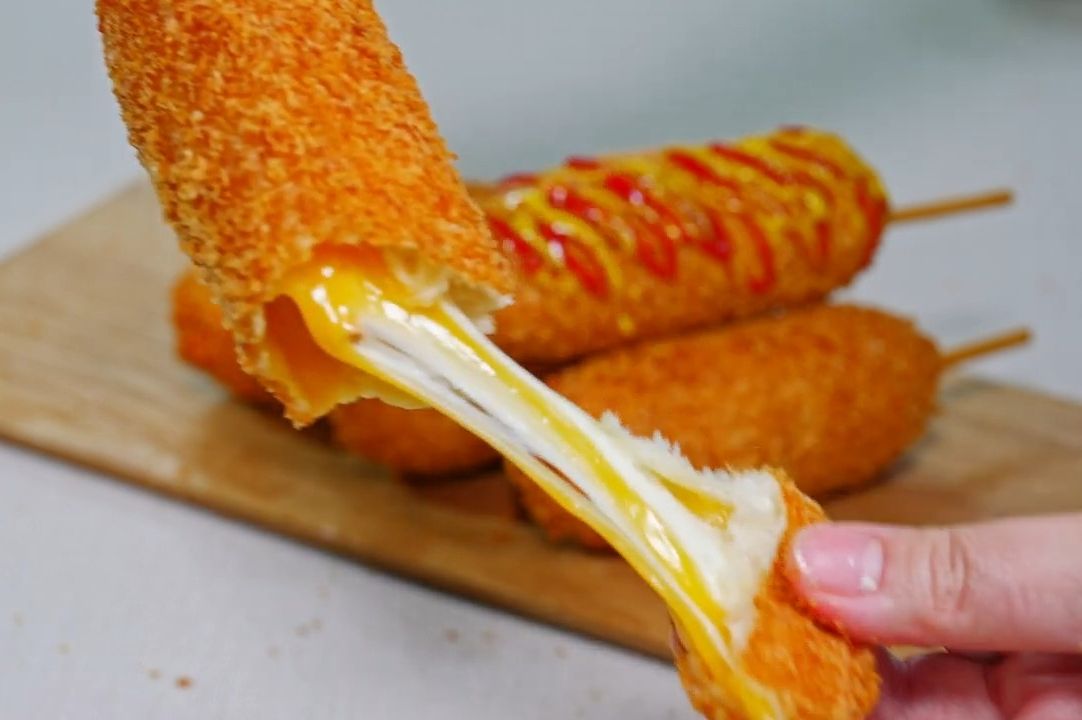 一块奶酪热狗,上面滴着奶酪,像瀑布一样.