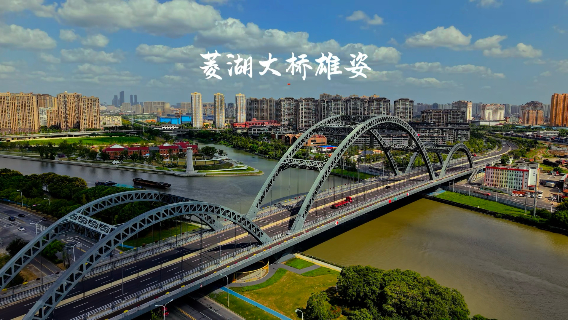无锡菱湖大桥是京杭大运河无锡段跨度最大的桥梁，主桥是一座造型现代的三跨中承式系杆拱桥，于2023年7月通车。大桥在蓝天白云的映照下显得格外雄壮。#航拍 无锡#