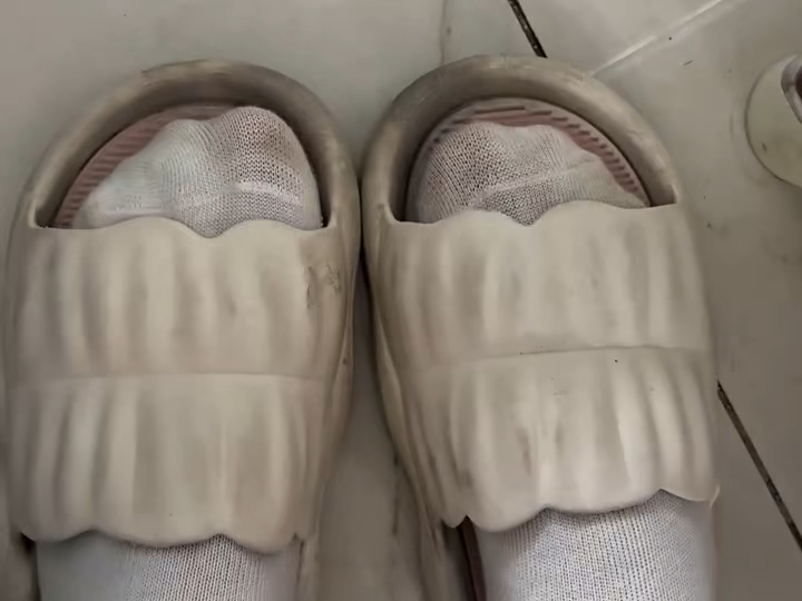 脚穿拖鞋袜子的人在瓷砖地板上行走的照片