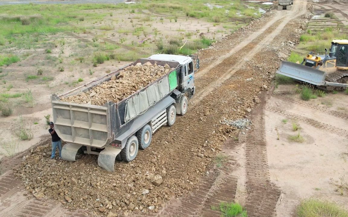 推土机和自卸车通过在沙土上填石建造新道路哔哩哔哩bilibili