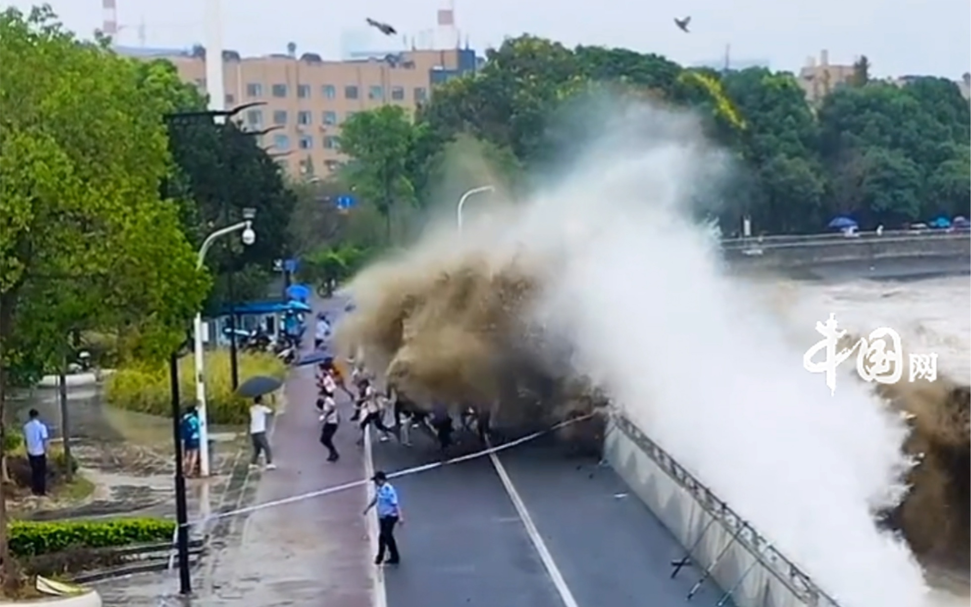 [图]近日，杭州钱塘江。游客钱塘江观潮不听警察叔叔的劝阻，潮水将众人冲倒在地秒变“落汤鸡”。注意安全！