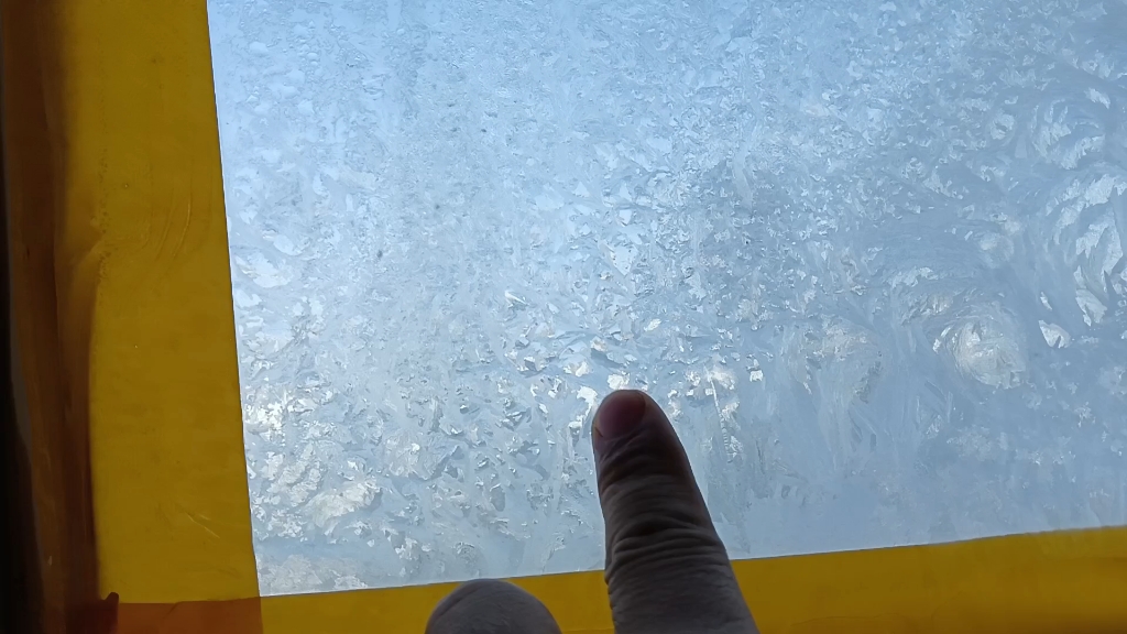 这窗户上都结冰了,屋里还吹着空调呢