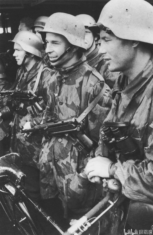 装备有两支mp40冲锋枪的空军野战师士兵,照片最前面的士兵的钢盔上有
